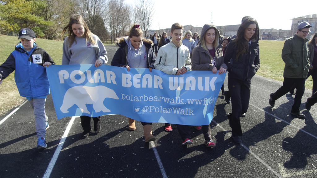 Students walk carrying Polar Bear Walk banner