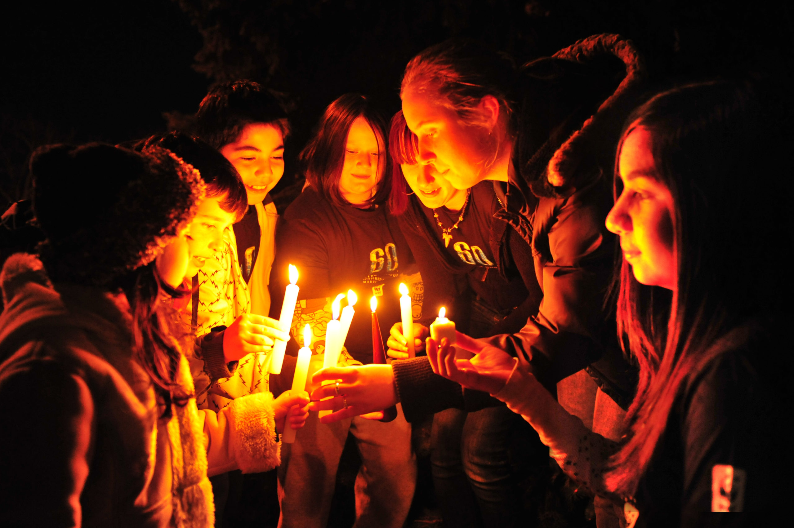 Students light candles in dark for earth hour